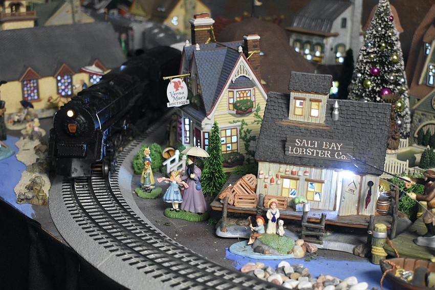 A train passes through the Christmas village setup.