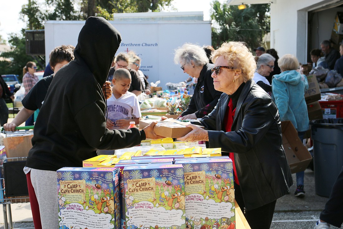 Volunteer Joan Swanson, of All Saints Lutheran Church, hands out pies during the Jewish Federation's 2021 thanksgiving food distribution event. File photo by Jarleene Almenas