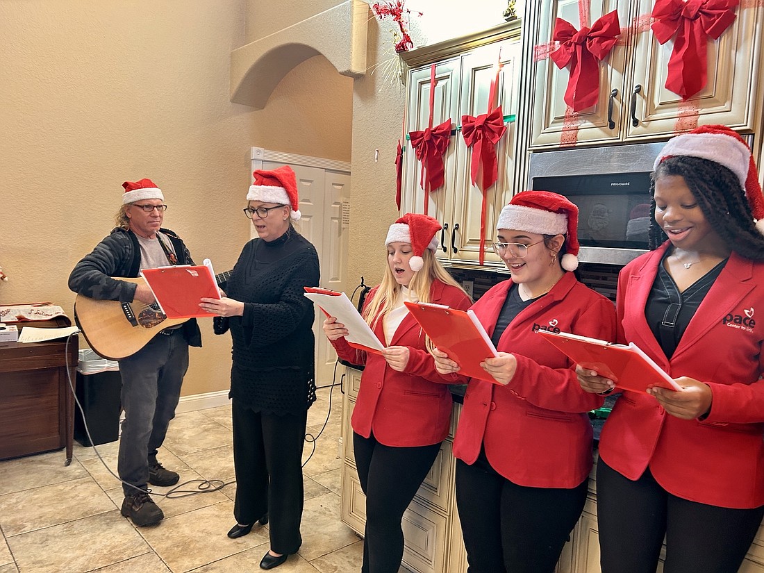 Pace Girls lead caroling at the Sarah House Assisted Living with Songwriters Showcases of America founding member Phil Weidner. Courtesy photo