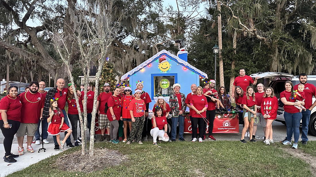 Security First Insurance team members pose with its float for the 32nd annual Home for the Holidays parade. Courtesy photo
