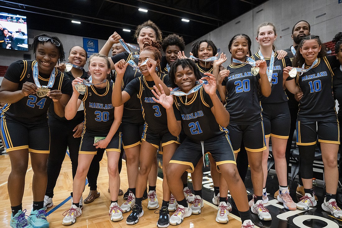 Mainland girls basketball players celebrate their state championship after receiving their medals. Photo by Michele Meyers