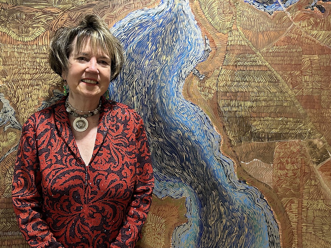Martha Barrett is retiring Dec. 28 as senior vice president, Jacksonville market executive, after 22 years at Bank of America. She is shown here standing in front of a painting by Jacksonville artist John Bunker displayed in the Bank of America Tower Downtown.