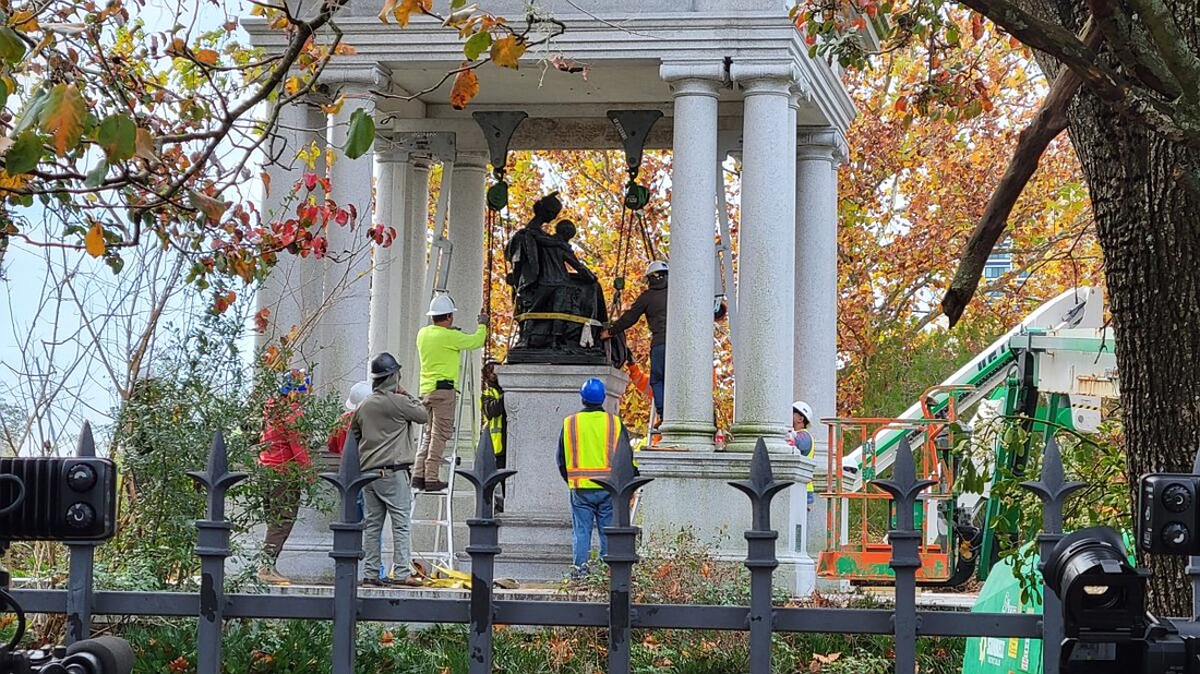 Workers prepare to remove the Tribute to the Women of the Southern Confederacy statue from Springfield Park on Dec. 27.