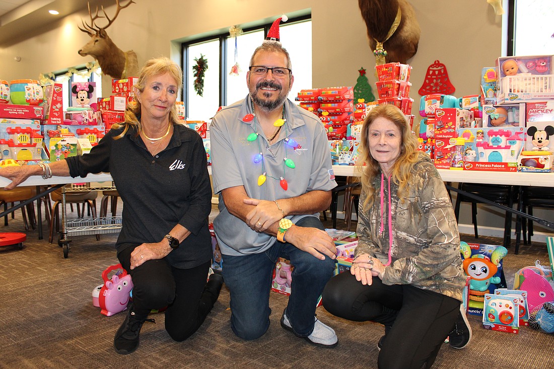 Lakewood Ranch Elks Co-event Chairs Faith Frost and Darrin Simone show Susan Goodman of the Myakka City Methodist Church some of the 10,000 toys they collected from Walgreen's stores during the Community Gift Drive.