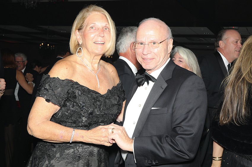 Dr. Gail Morrison Morganroth and Dr. Joel Morganroth, Board of Trustee chair, cut the rug together.