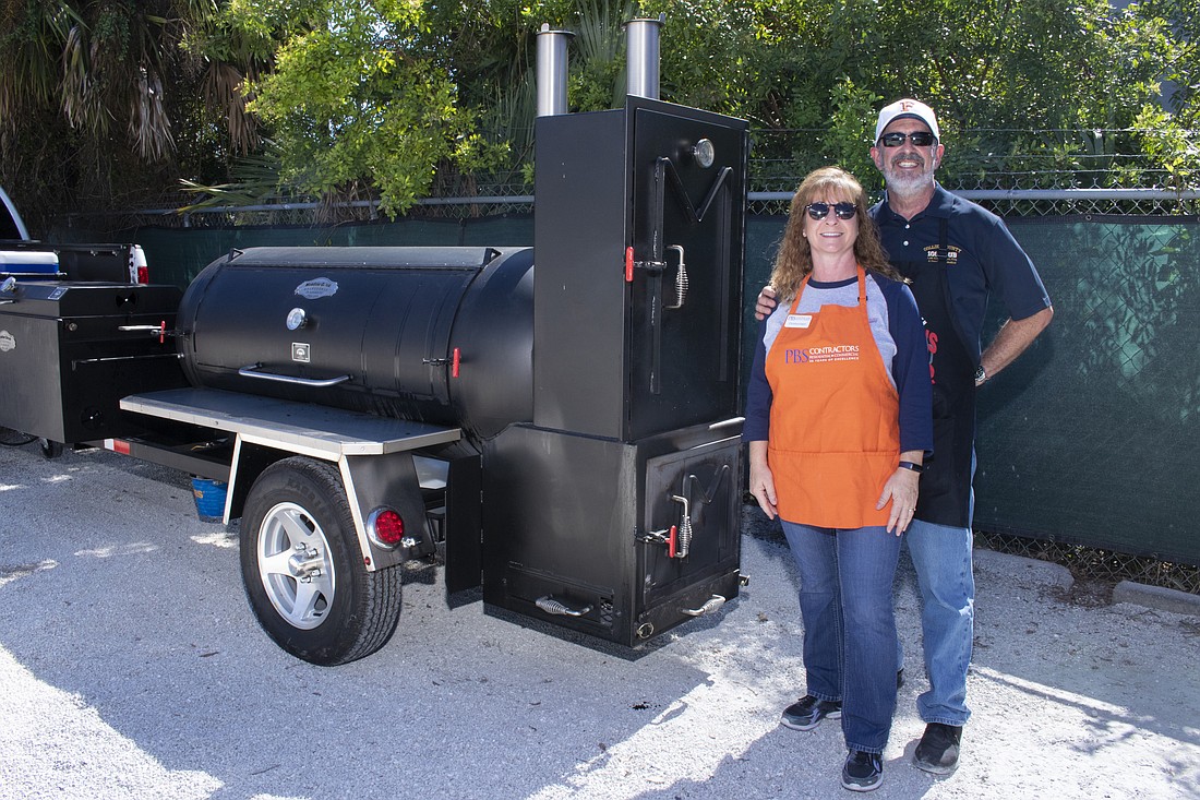 Christina Hatch of PBS Contractors and Russell Budd, who says he loves the socializing and camaraderie side of grilling meats.