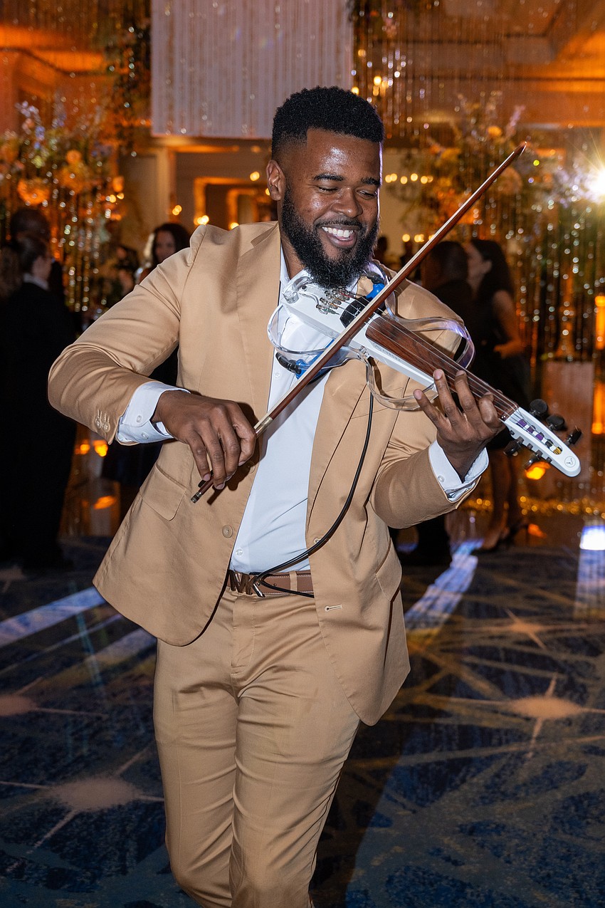 A violinist entertains guests as they arrive.