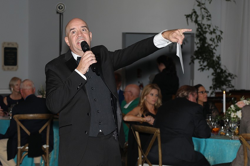 Auctioneering the many donations is Director of Education Tim Ferguson, whose passion contributed to the paddle raising.