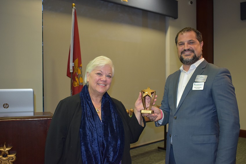 Alice Baumann, president of Aloha Ukulele, receives the Best Group or Club award from Keith Pandeloglou.