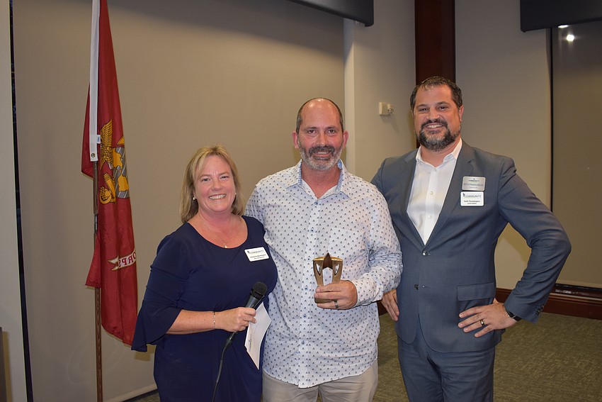 LWRCF Executive Director Adrienne Bookhamer gives the Volun-told award to her husband Doug Bookhamer for his volunteer work over the past year. Keith Pandeloglou also presented.