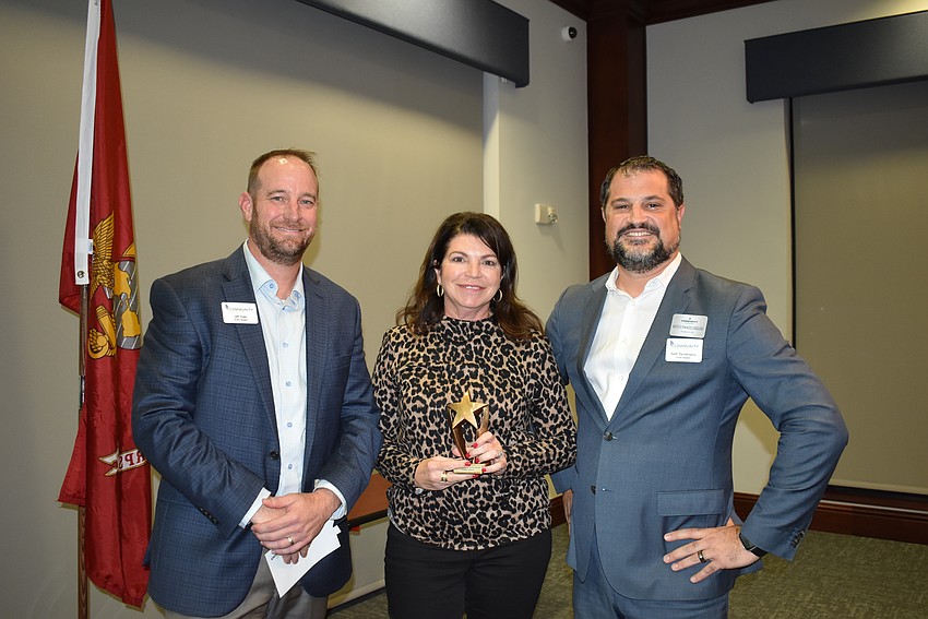 Jeff Toale, left, and Keith Pandeloglou, right, give Debbie Urban the Rookie of the Year award.