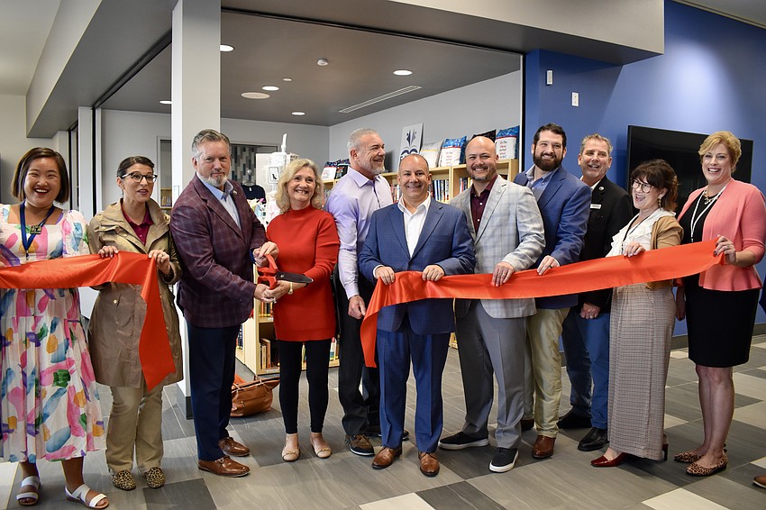 Former Commissioner Vanessa Baugh (in red) joins current commissioners and dignitaries in cutting the ribbon at the opening of the Lakewood Ranch Library on Jan. 12.