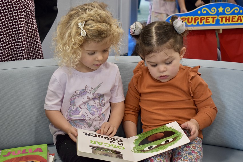 Madisyn Murphy and Catalina Hayes look at a Sesame Street book together. As 3-year-olds, they're future readers.