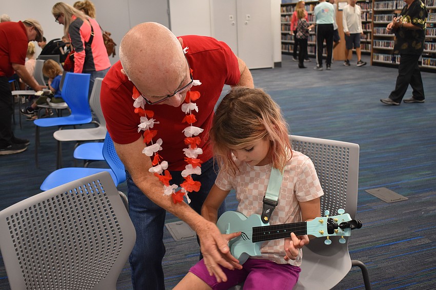 Warren Lee from Aloha Ukulele of Lakewood Ranch offers some tips to 7-year-old Hope Fisher.