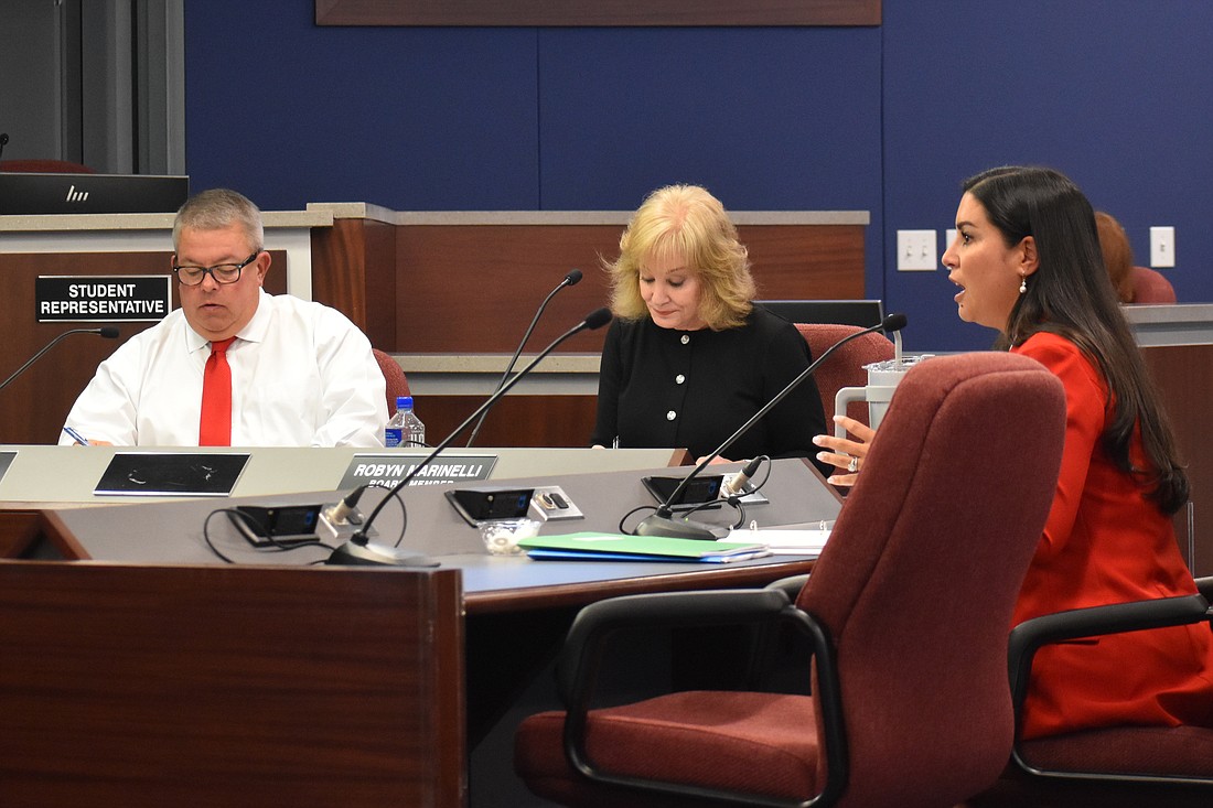 Board members Tim Enos and Robyn Marinelli listen to a presentation by Rachael O'Dea, the deputy superintendent and chief academic officer, on "Literacy for All."