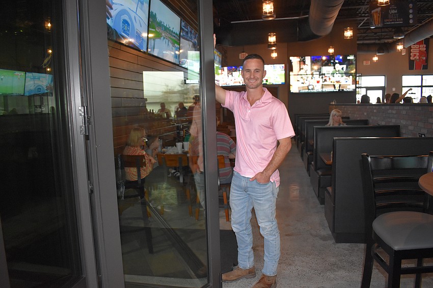 Ben Peacock of MMP Contracting of Bradenton shows off the unique glass doors that open up the indoor part of the restaurant to the patio.