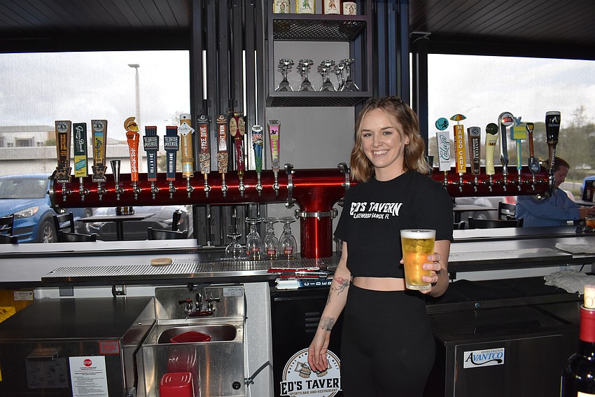 Bartender Ashlyn Davis serves up a draft beer during the soft opening Friday at Ed's Tavern. The tavern has 26 beers on tap.