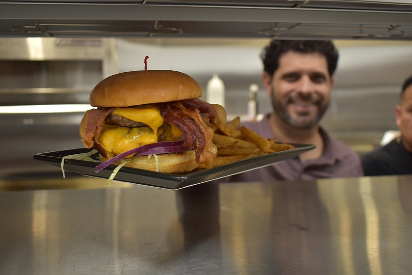 Co-owner Adam Myara serves up a smashburger to the wait staff in the Ed's Tavern kitchen. The new Ed's Tavern had a soft opening for its second Lakewood Ranch location on Friday.