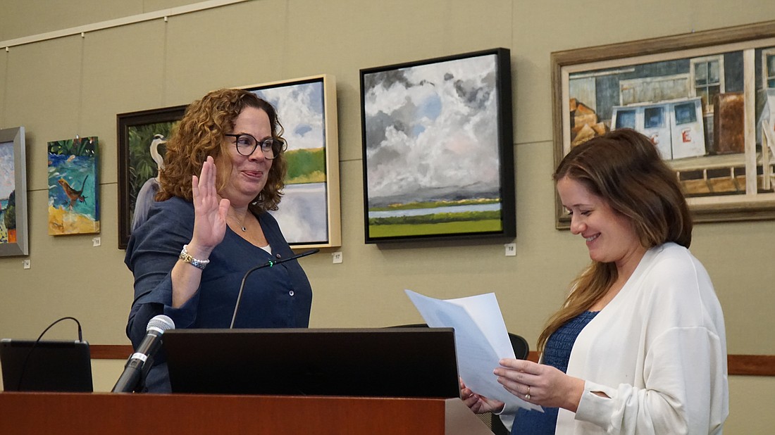 Deputy Town Clerk Savannah Cobb (right) swears in Sarah Karon to the District 5 commission seat.