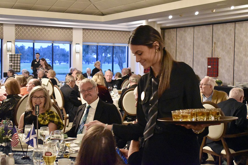 Stella Randazzo serves shots of scotch to the guests.