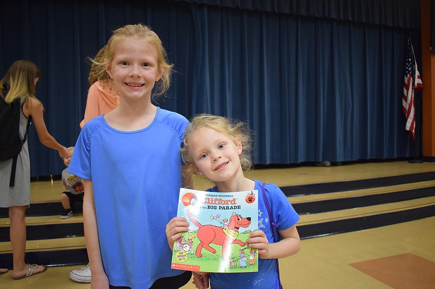 First grader Paisley Shewbridge celebrates her sister Riley Shewbridge, who is in pre-K, winning a book in a dance party.