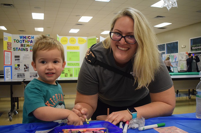 James Erickson, who is 2 years old, and his mother, Naomi Erickson, spend time coloring while his sister, Chloe Erickson, a second grader, participates in a dance party.