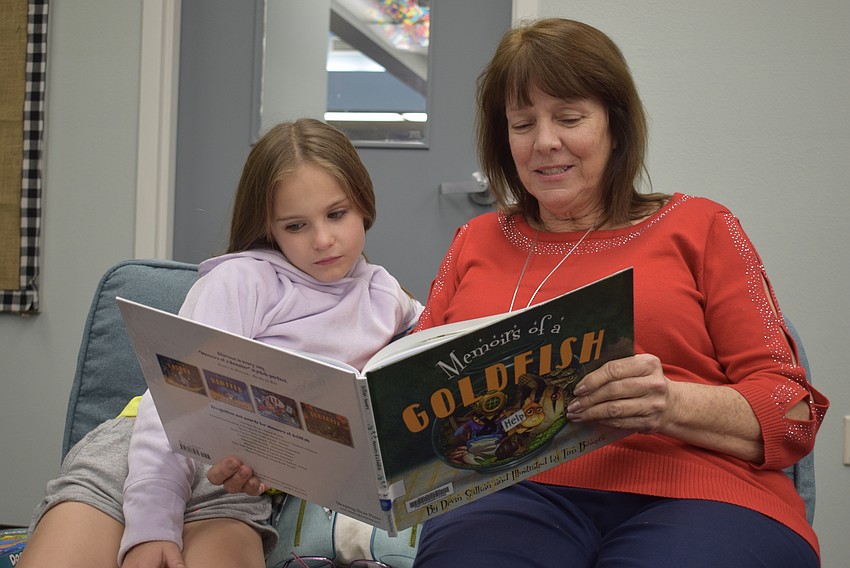 Second grader Lydia Powell listens intently and follows along as second grade teacher Karen Washington reads aloud.