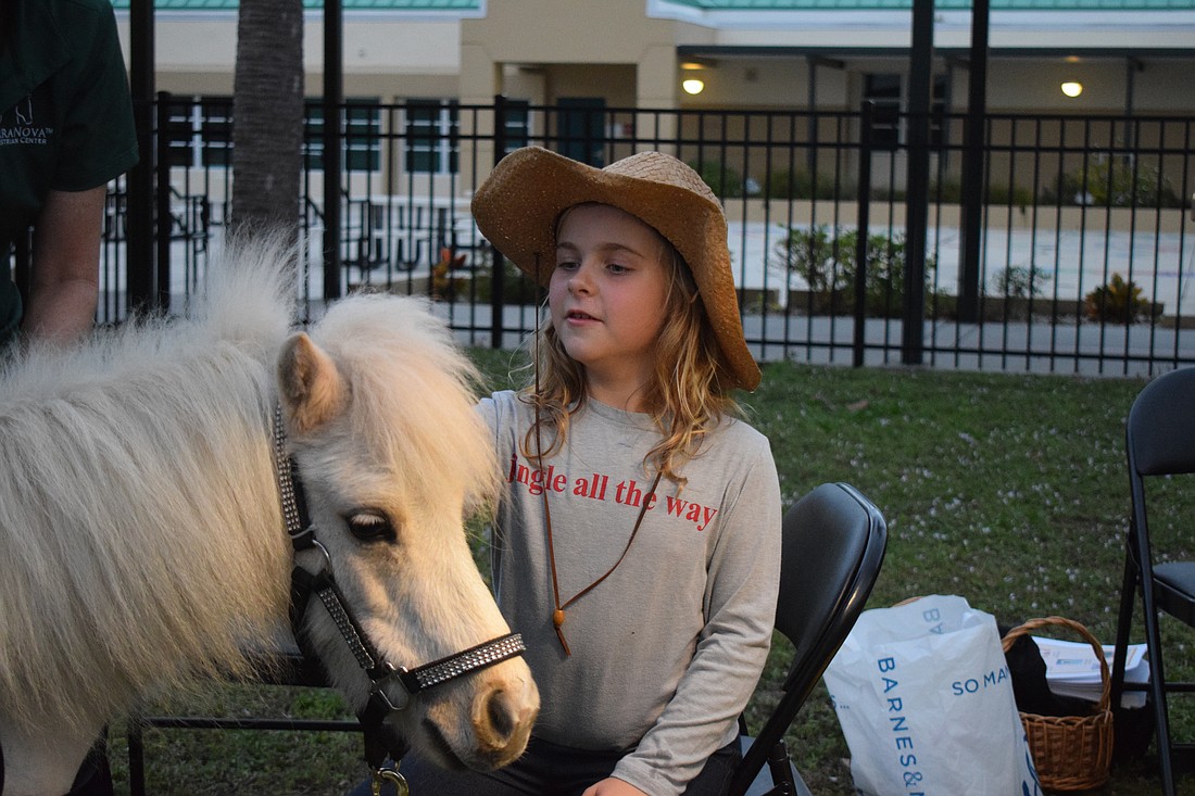 First grader Penelope Seguin, who loves horses, takes her time petting Sugar, a mini horse, after reading "Pete the Cat Goes to the Doctor."