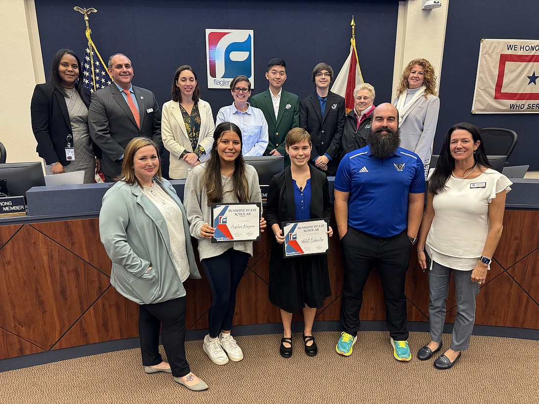 Flagler Schools honored Sunshine State Scholar Violet Ochrietor (center front) and alternate Angelina Manjarres (second from left) at the Jan. 23 School Board meeting. The students, FPC Assistant Principal Mandy Kraverotis, Matanzas Assistant Principal Josh Scott and Science Curriculum Specialist Heidi Alves poses with the School Board. Courtesy photo/Flagler Schools