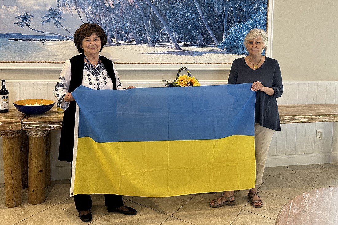 Anisa Mycak and Tania Vitvitsky hold up the Ukrainian flag.