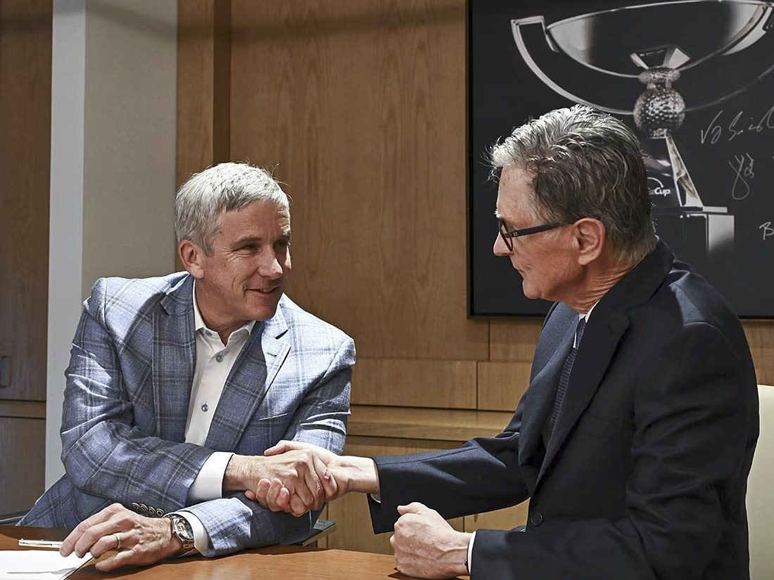 PGA Tour Commissioner Jay Monahan, left, and John W. Henry, Principal owner of Fenway Sports Group and manager of the Strategic Sports Group, finalize the launch of PGA Tour Enterprises.