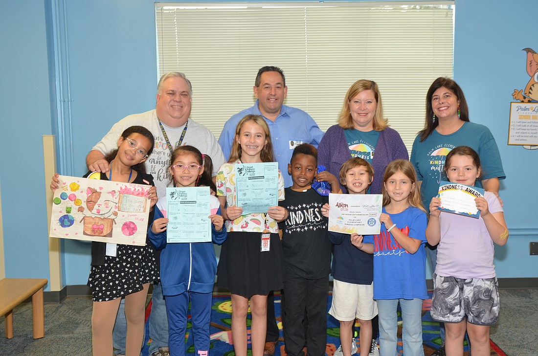 Principal James Weis, left, Matt and Amy Allen, and school counselor Lauren Akesson recognized students at Palm Lake Elementary School for being kind.