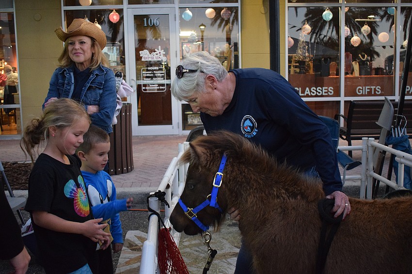 Lakewood Ranch 6-year-old Vivian Bodamer and 4-year-old Brody Bodamer feed Rocky, a mini horse, with the help of Ellie Wenzke, a volunteer for Sarasota Manatee Association for Riding Therapy.
