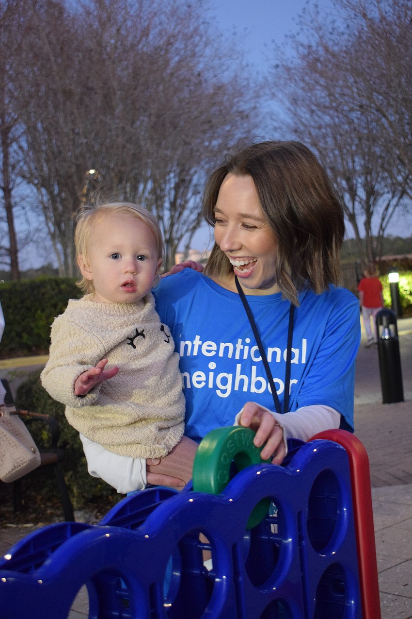 Rhysand Heller, who is 14 months old, plays Connect 4 with Macala Heller, who is a volunteer for Grace Community Church.