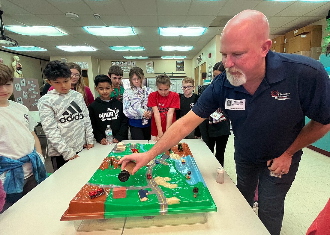 Michael Hager, a water conservation compliance officer with Manatee County Utilites, takes fifth graders through an interactive watershed model to help students understand the importance of water conservation.