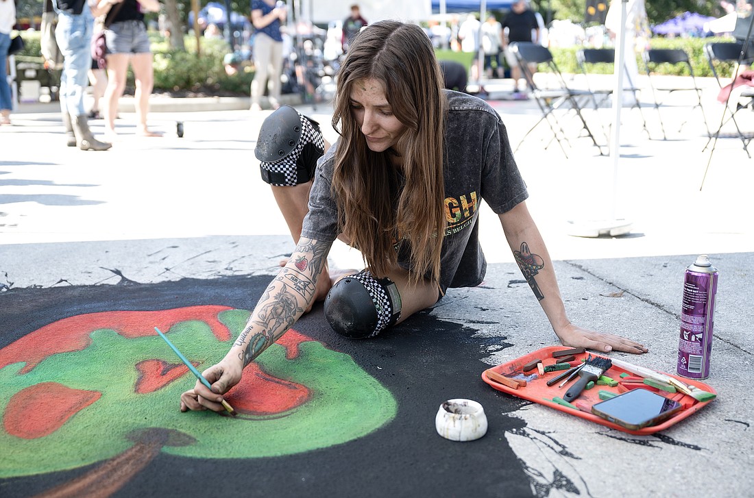 Artist Nikki Brown works on her art during the ArtHaus chalk art competition at the 10th annual Granada Grand Festival of the Arts. Photo by Michele Meyers