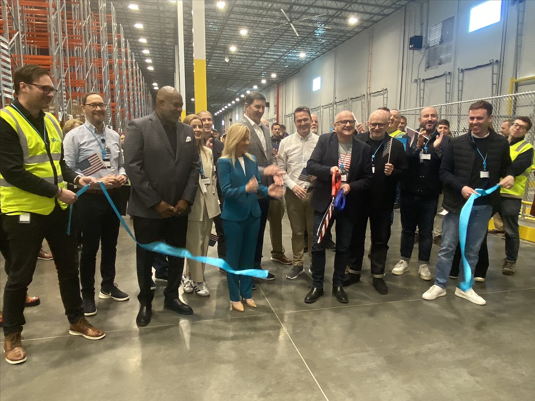 Mark Shirley, Primark director of logistics, cuts the ribbon at the clothing retailer’s new distribution center in North Jacksonville on Feb. 7. Also pictured are Mayor Donna Deegan, standing at Shirley’s right; JaxPort CEO Eric Green, standing beside Deegan; and Kevin Tulip, president of Primark US, holding ribbon at far right.