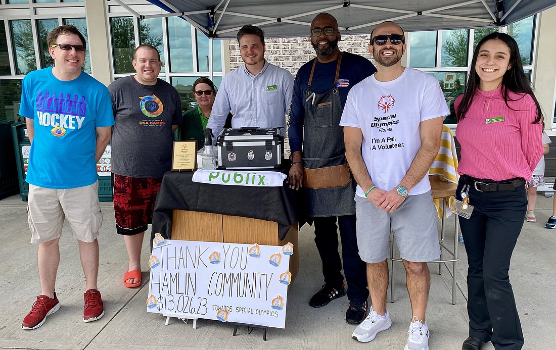 Hamlin Publix Store Manager Josh Fahlstrom, second from right, had his head shaved by Noel Gonzalez, a meat cutter at another Publix location in Winter Garden.