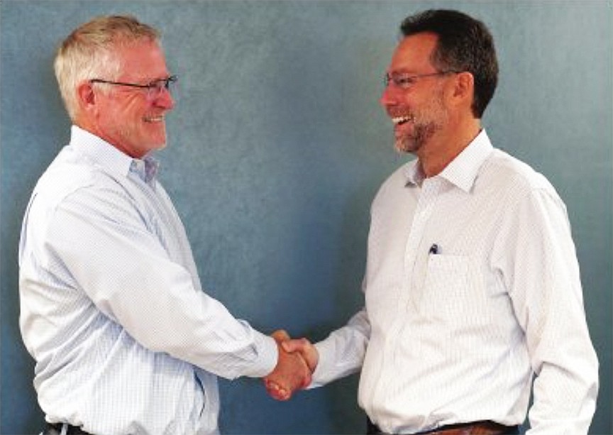 Left, retiring Landstar System Inc. CEO Jim Gattoni shakes hands with his successor, former CSX Corp. executive Frank Lonegro. Gattoni retired Feb. 2 after 28 years with the Jacksonville-based company.