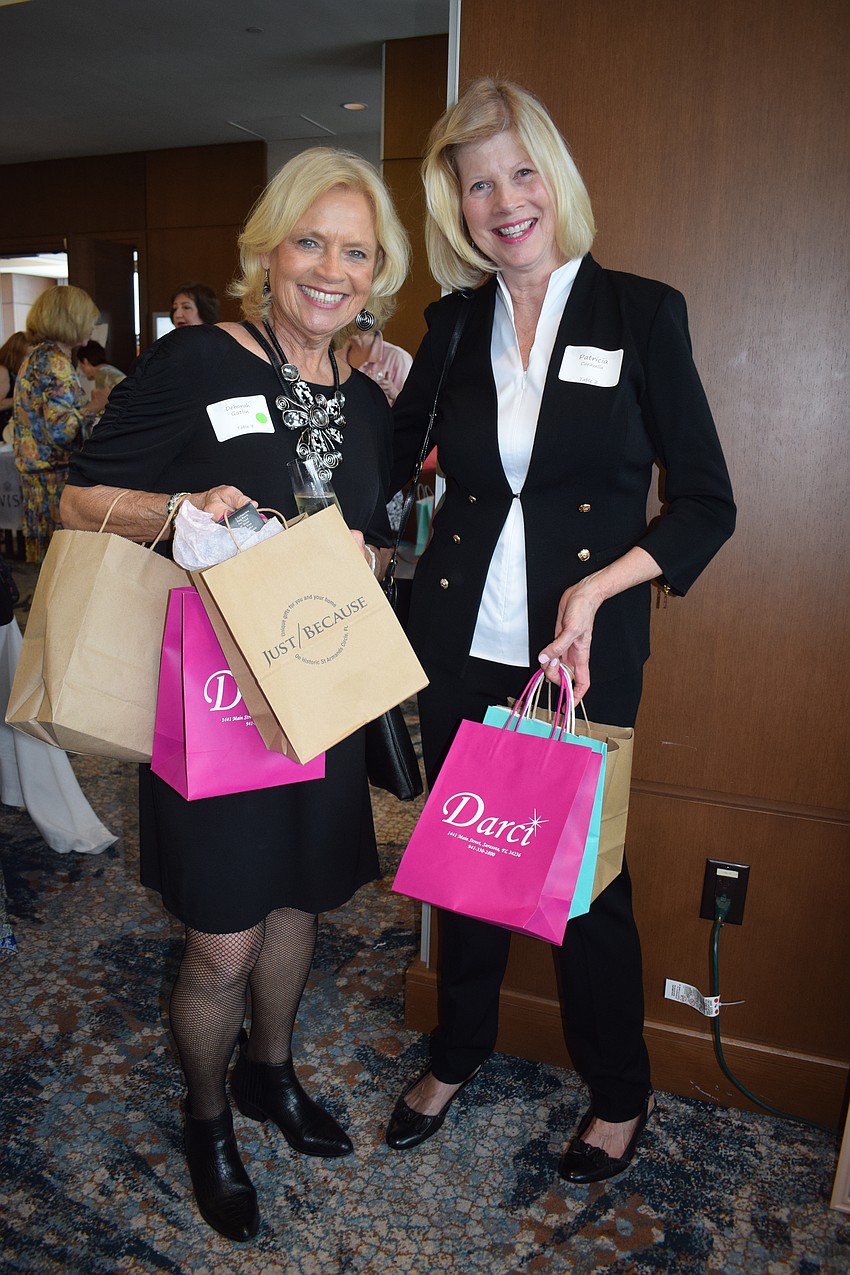 University Park's Deborah Gatlin and Patty Caravella show off what they purchased from the local boutiques at the University Park Women's Club Fashion Show.