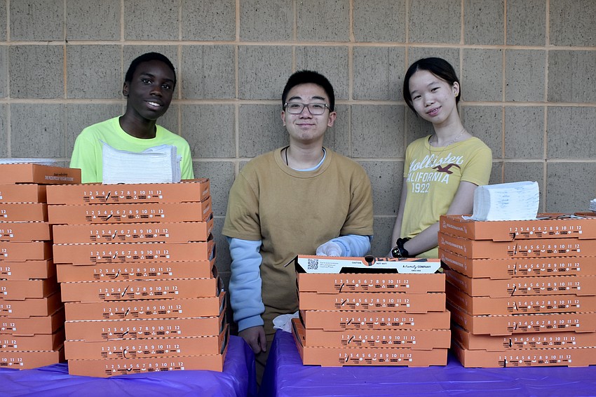 Andrew Ashby, David Ma and Sophia Lander, ninth graders at Pine View School, served pizza to attendees.