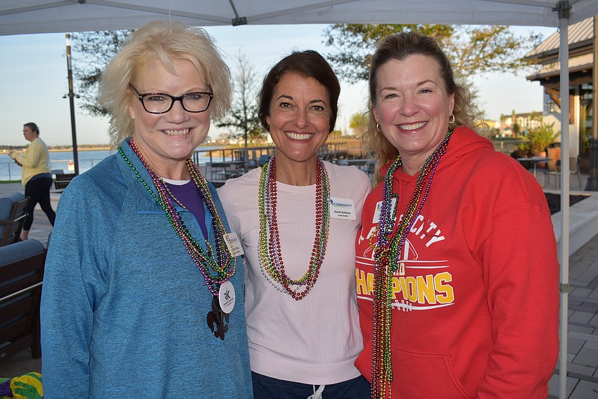 Lakewood Ranch Community Foundation Board Members Nancy Sykes, Nicole Ryskamp and Lorri Kidder work the registration desk before Run for the Beads Feb. 10 at Waterside Place.