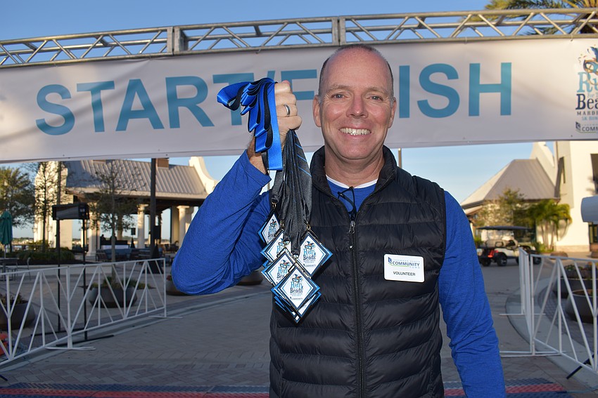 Run for the Beads Co-Chair David Ahrens gets ready to hand out race medals.