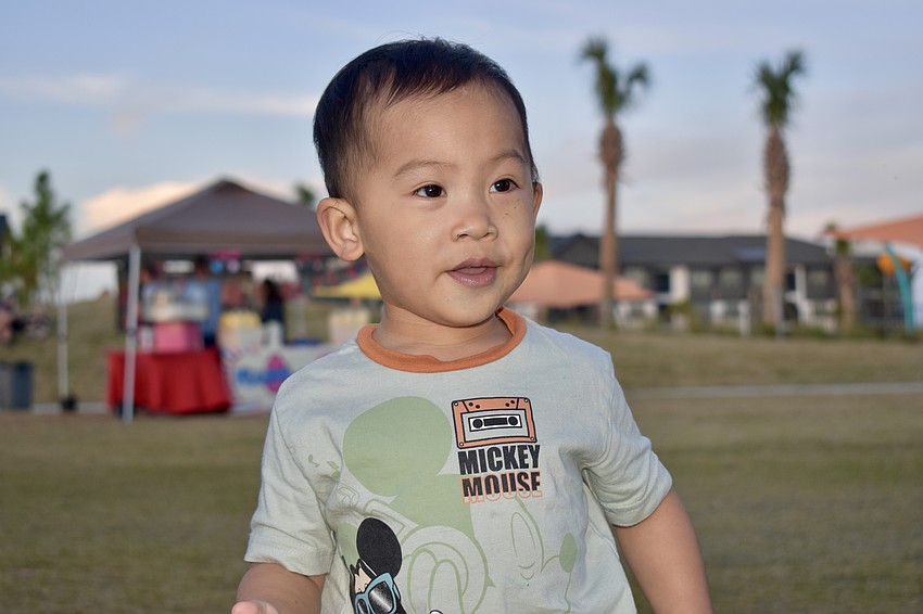 Elijah Pan, 2, hasn't had his face painted yet, but he's tried both the pizza and cotton candy.