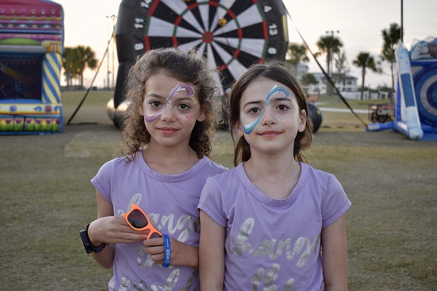 Greyhawk Landing residents Gabriella and Isabella Cardoso, 7-year-old twins, are among the first in line to get their faces painted to match the 