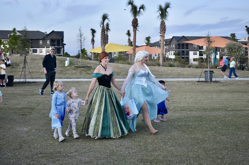 Anna and Elsa walk their fans over to a better photo spot. The sisters were mobbed with hugs the minute they arrived.