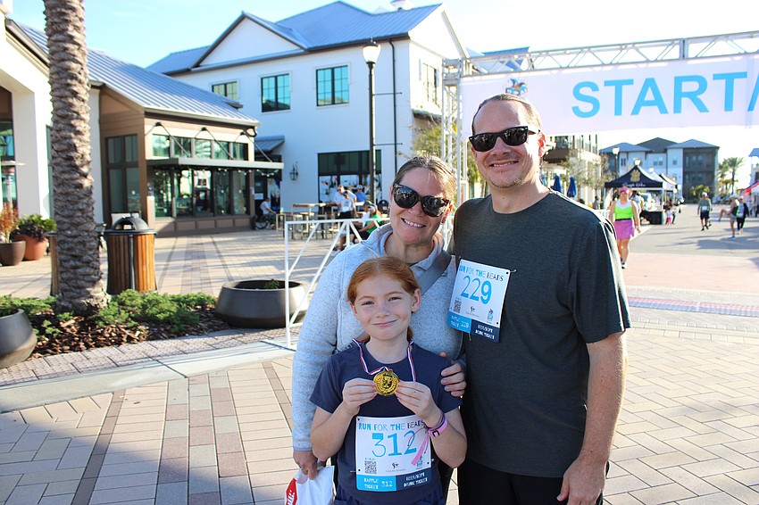 Lakewood Ranch's Hadley Smith, 9, shows off her medal in front of proud parents Jen and Erick Smith.