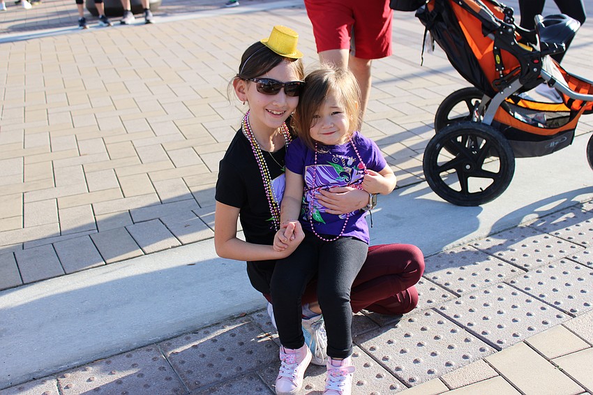 Lakewood Ranch 11-year-old Harper Profito gives her sister, 3-year-old Ellie Profito, a place to sit before the race.