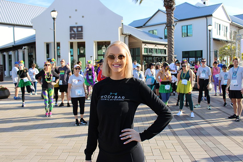 Summer Garcia, the general manager of BodyBar Pilates at Waterside, helps the runners stretch out before the start of the race.