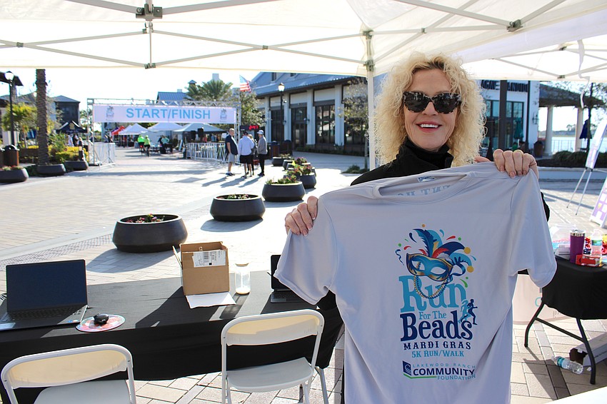 Nyda Bittmann Neville, who serves on the Lakewood Ranch Community Foundation board of directors, gets ready to hand out a race t-shirt at Waterside Place.